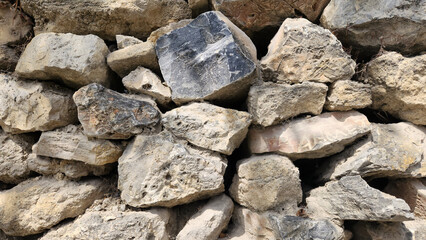 Wall made of black stones serves as the boundary of a rustic village house garden.