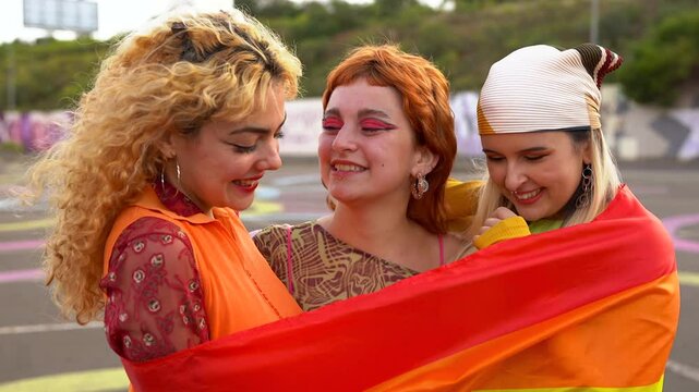 Group of young women at LGBT gay pride parade with rainbow flag - Party and people concept 