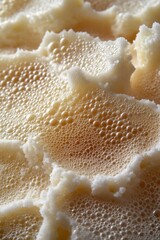Fototapeta premium Creamy foam texture close up with delicate bubbles creating a soft and airy visual experience in macro photography