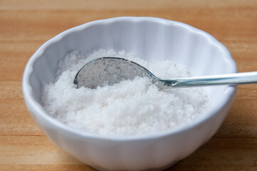 Close up of a spoon filled with coarse salt with customizable space for text or ideas
