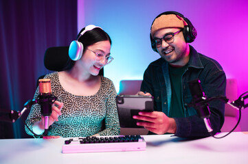 Teenagers, men and women, host podcasts in a room using LED lights, computers, headphones,...