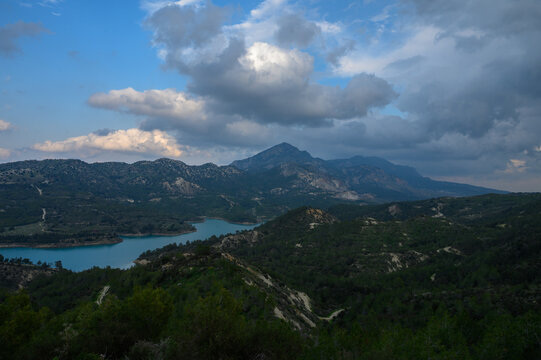 Breathtaking view of the tranquil lake and majestic mountains under a dramatic sky at dusk in a remote natural landscape