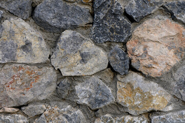 Natural stone wall brings rustic charm to outdoor garden space in sunlight
