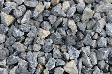 Natural gravel stones in various shades laid out in a textured surface capturing light and shadow...