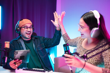 Teenagers, men and women, host podcasts in a room using LED lights, computers, headphones,...