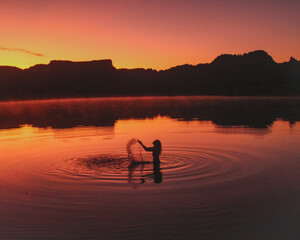 silhueta de mulher nas águas da lagoa da serra no por do sol em rio da conceição, tocantins