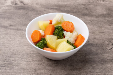 Cooked vegetables in a plate over wooden table