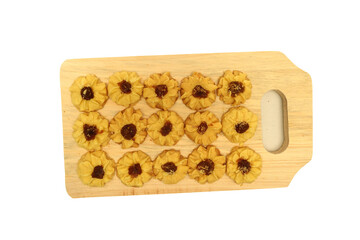 Kue semprit or Butter Cookies is a Traditional Indonesian Cookies, pineapple jam on top for Ied Al Fitr served on Wooden cutting board  and isolated on white background 