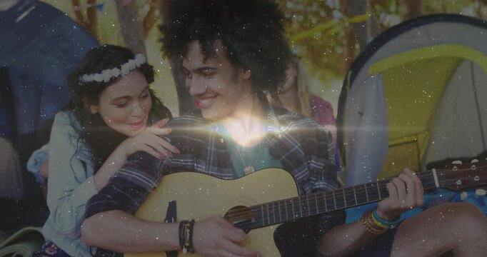Playing guitar outdoors, couple smiling and listening to music together