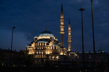 Obraz premium Illuminated Yeni Camii Mosque at Night in Eminönü, Istanbul - Historic Ottoman Architecture with Magnificent Domes and Minarets Against Twilight Sky in Turkey