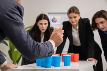 Team Building Game with Blue and Red Cups in Office