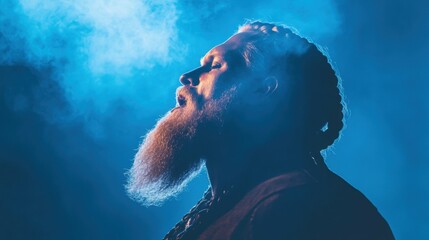 Bearded caucasian adult male in profile with blue smoke