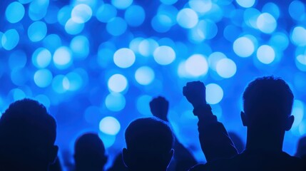 Silhouettes of diverse crowd against blue bokeh background at night event
