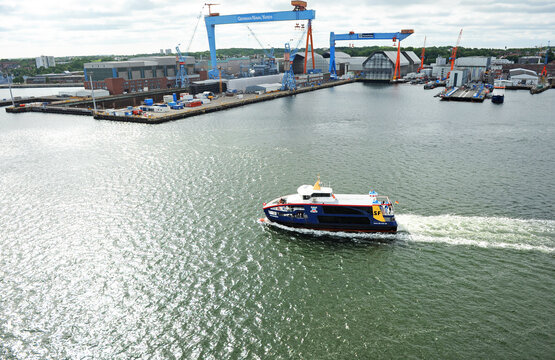 SFK Hybrid ferry Gaarden in ​​the port of Kiel with the gantry cranes of the German Naval Shipyards and ThyssenKrupp Shipyards standing out. Kiel is the capital of Schleswig-Holstein, Germany.
