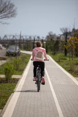 Fototapete Rund A woman is riding a bicycle down a path © Prikhodko