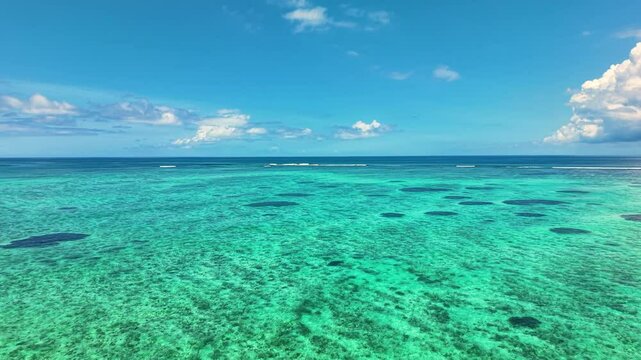 Mesmerizing Aerial View Of Shallow Coral Lagoon With Dark Patches Contrasting Against Brilliant Turquoise Sea