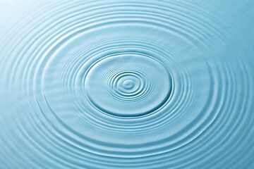 Serene ripples expanding outwards in a tranquil blue water surface, showcasing a calming and peaceful moment.