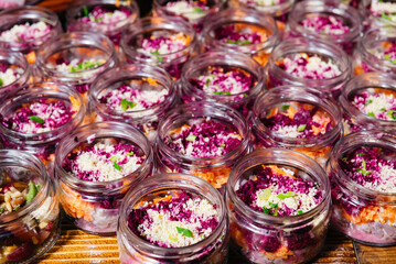 Beetroot and carrot salads in glass jars.