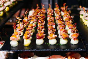 Prosciutto melon bites with mango sauce skewers.