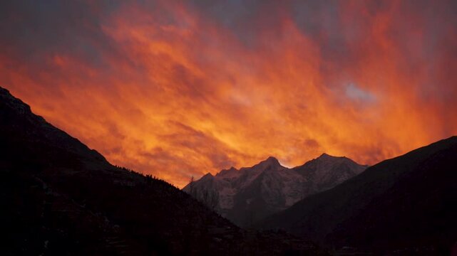 Beautiful Himalaya mountains during fiery red sunset at Keylong, Himachal Pradesh, India. Orange color clouds over mountains during evening. Sunset landscape.