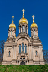 Fassade der Russisch-orthodoxen Kirche auf dem Neroberg in Wiesbaden im Sonnenlicht bei wolkenlosem, blauem Himmel