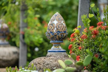 Ornate ceramic sculpture in a vibrant garden.