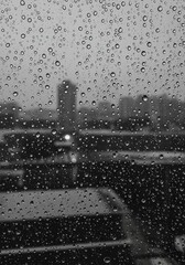 雨粒越しに滲むモノクロの都市風景