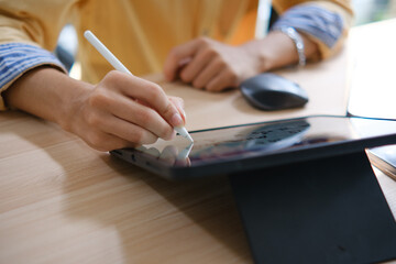 Male web designer drawing with graphic tablet at table in office.