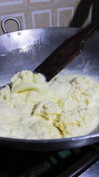 Hands of an unrecognizable person mixing a substance in a pot to prepare Quesillo Yaguare&ntilde;o inside a kitchen in Yaguar&aacute;, Huila, Colombia. Colombian food concept