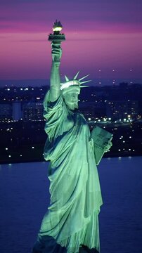 Aerial view of the Statue of Liberty at dusk. Manhattan and New Jersey skyline. New York City, United States. Shot from helicopter.