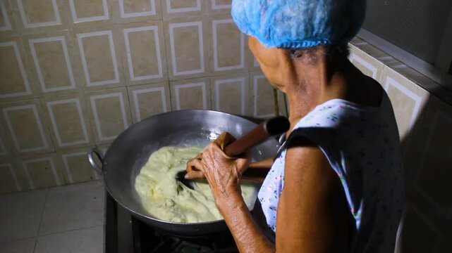 A colombian woman mixing a milk drink in a pot to prepare the typical Quesillo Yaguare&ntilde;o in Yaguar&aacute;, Huila, Colombia. Artisanal food concept
