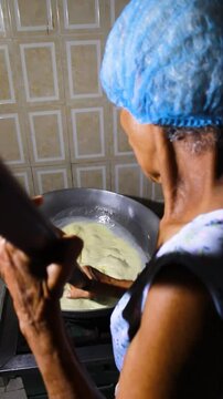 A hispanic woman mixing a milk drink in a pot to prepare the typical Quesillo Yaguare&ntilde;o in Yaguara, Huila, Colombia. Colombian food concept
