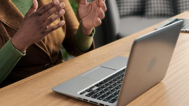 AI animated closeup of hands of unrecognizable young African American female psychoanalyst gesticulating while speaking to patient during therapy session, sitting at desk in front of laptop