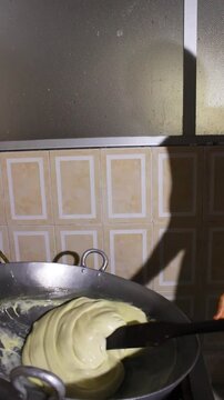 A hispanic woman mixing a milk drink in a pot to prepare the typical Quesillo Yaguare&ntilde;o in Yaguara, Huila, Colombia. Colombian food concept