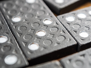 Dominoes arranged for a game. The tiles are black with white dots a classic pattern-rich image.