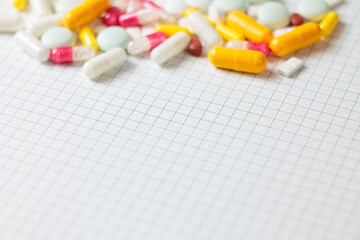 A variety of pills in the background: bright medicines and their packaging, representing the pharmaceutical industry and human health.