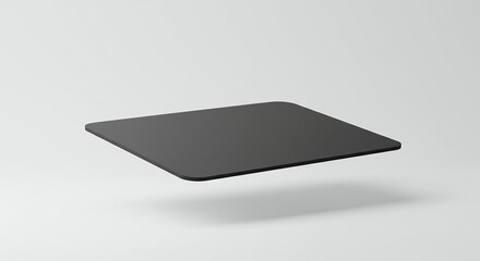 Sleek graphite pad hovering over subtle backdrop creating an intriguing spatial effect