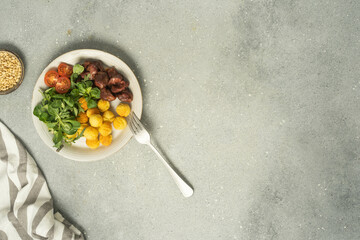 Chicken bites with potato balls, salad and dressing.