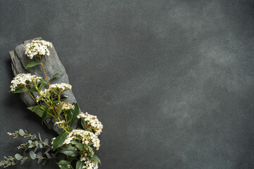 Bouquet of white flowers on dark rustic background.