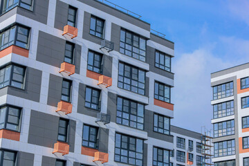 Fototapeta premium Contemporary apartment complex featuring sleek architecture and air conditioning, set against a clear blue sky.