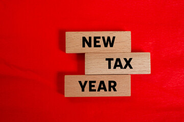 New tax year message written on wooden blocks on red background. Conceptual new tax year symbol....