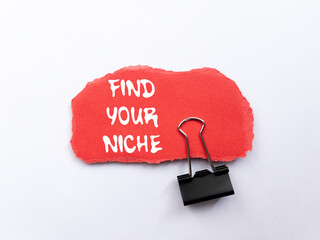 Find your niche message written on ripped torn red paper piece on white background. Conceptual find...