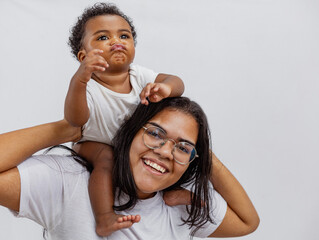 Beautiful Brazilian mother hugs and kisses her baby in the studio on a white background. A young...