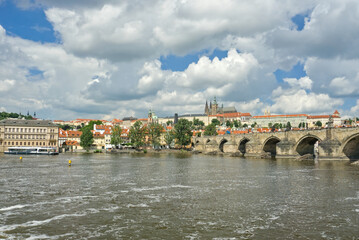 Panoramic view of Prague featuring the Charles Bridge and the Vltava River with the city skyline...
