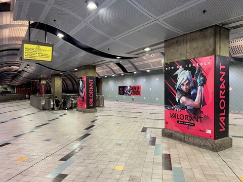 LOS ANGELES, CA, AUG 15, 2024: wide angle view, empty Hollywood-Highland LA Metro station interior with Valorant video game advertisements, yellow information sign, escalators, and tiled floor