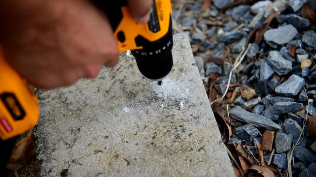The man Use Cordless drill to drill the Concrete 