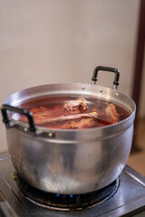 A close-up shows pieces of what appear to be beef ribs simmering in a pot of broth.