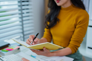 
Asian woman in yellow shirt talking business in office