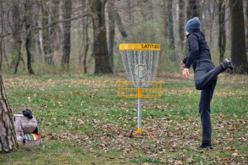 Woman and Disc golf basket with final shot disc