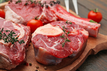 Pieces of raw beef, tomatoes and spices on wooden table, closeup